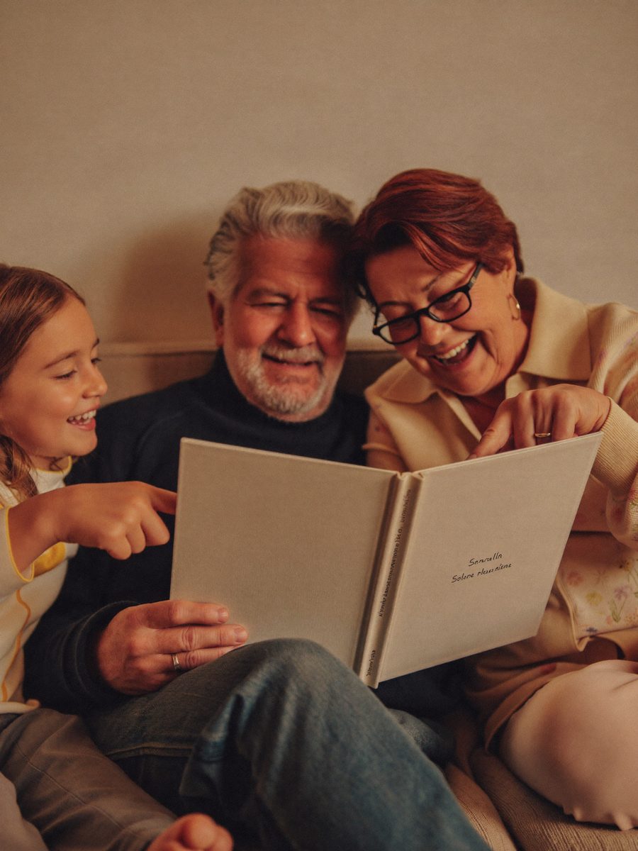 Des grands-parents lisent leur livre imprimé avec leur petite-fille